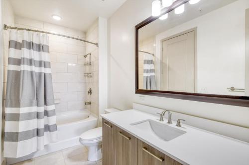 a bathroom with a sink and a toilet and a mirror at Lovely Doral 2BR Pool Gym MIA-16 in Miami
