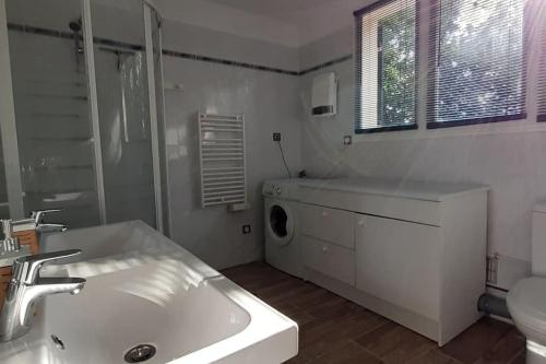 Baño blanco con lavabo y aseo en Magnifique coin de mas avec piscine privative, en Meynes