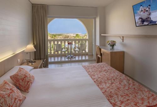 Habitación de hotel con cama y balcón en Gran Hotel del Coto en Matalascañas