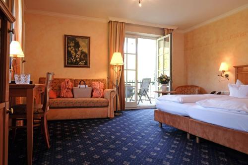 une chambre d'hôtel avec un lit et un canapé dans l'établissement Hotel Molitors Mühle, à Eisenschmitt