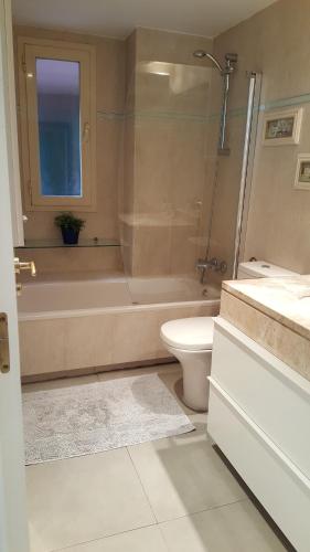 a bathroom with a tub and a toilet and a shower at Madrid Las Tablas apartments in Madrid