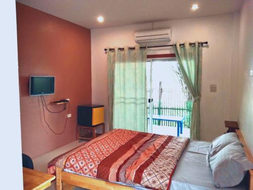 a bedroom with a bed and a window at บ้านสวนสุขใจ รีสอร์ท in Ban Makok