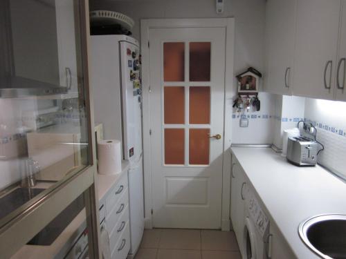 a kitchen with white cabinets and a white door at Madrid Las Tablas apartments in Madrid