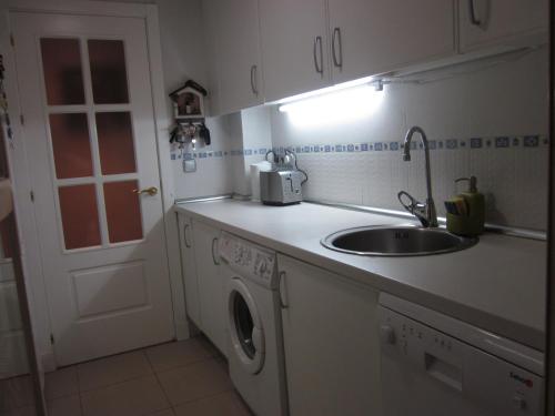 a kitchen with a sink and a washing machine at Madrid Las Tablas apartments in Madrid