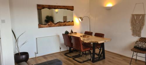 uma mesa de jantar com cadeiras e um espelho em The Cornish Getaway em Newquay