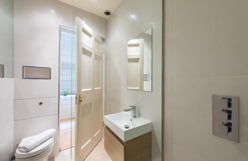 a white bathroom with a sink and a toilet at Luxurious city centre self catering apartment in Edinburgh