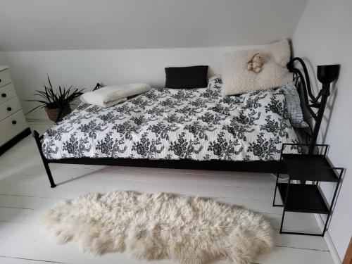 ein Bett mit einer schwarzen und weißen Bettdecke und einem Teppich in der Unterkunft Urlaub im Haus an der Bucht in Nordborg