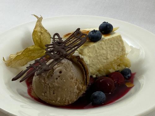 een witte plaat met een stuk cake en bosbessen bij Hotel Molitors Mühle in Eisenschmitt