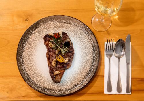 a piece of food on a plate next to a fork and knife at Amirey Hagalil Boutique Hotel in Amirim