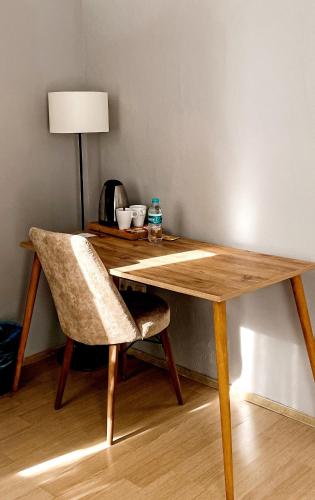einem Holztisch mit einem Stuhl und einem Schreibtisch mit einer Lampe in der Unterkunft Private Villa Room Near Airport in Arnavutköy