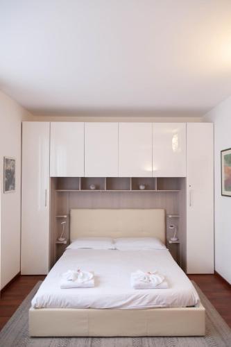 a bedroom with a white bed with white cabinets at I Cigni in Basiglio