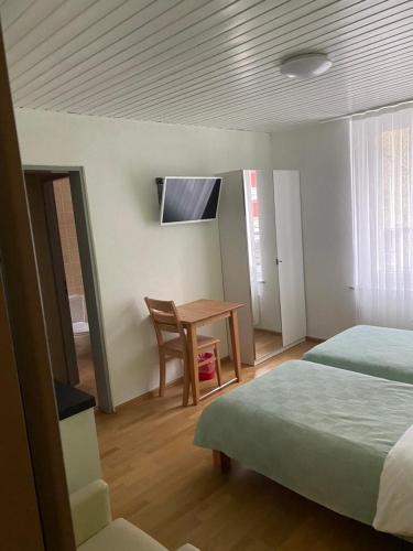 - une chambre avec un bureau, un lit et une table dans l'établissement Studios with Kitchenette, à Bâle