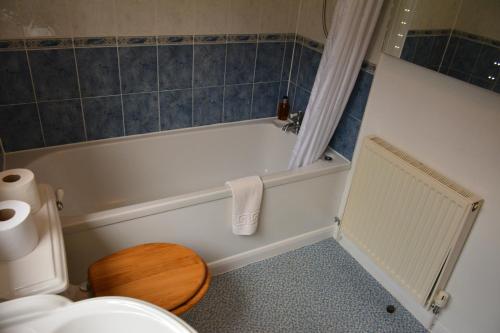 a bathroom with a white tub and a toilet at Woodpecker Way at Eaton Manor in Eaton