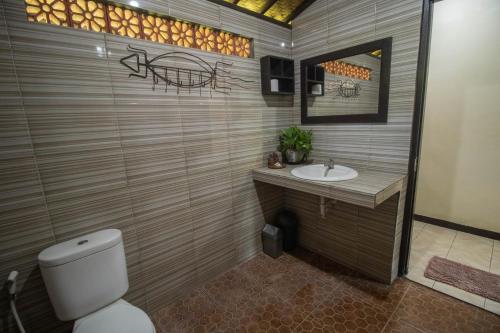 La salle de bains est pourvue de toilettes et d'un lavabo. dans l'établissement Giri Sari Guest House Pemuteran Bali, à Pemuteran