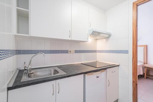 eine Küche mit weißen Schränken und einem Waschbecken in der Unterkunft Apartamento Felipe 2-2 in Cala d´Or