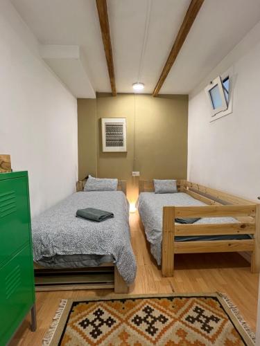 Cette chambre comprend 2 lits et une table. dans l'établissement Precioso apartamento en el centro de Esparreguera, à Esparraguera