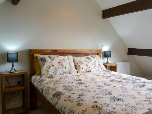 a bed in a bedroom with two lamps on tables at Loyal Cerise in Cawood