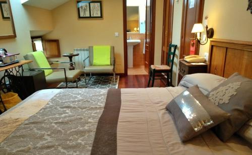 1 dormitorio con 1 cama y sala de estar con sillas verdes en Hotel Casa Vieja del Sastre, en Soto de Luiña
