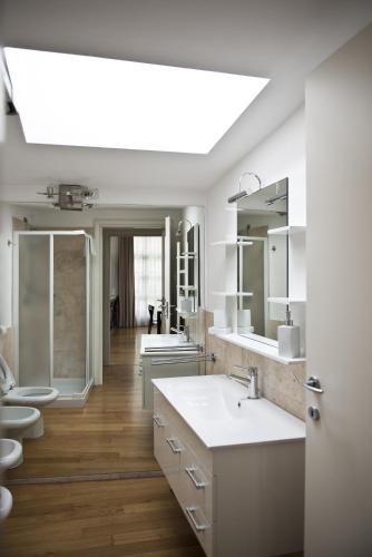 a white bathroom with a sink and two toilets at La Maison del Capestrano in Milan