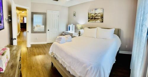 a bedroom with a large white bed with white pillows at Eclectic 3 bedroom townhouse with back terrace in Tallahassee