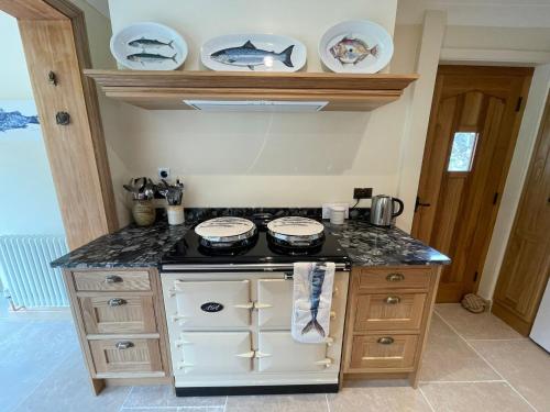 a kitchen with a stove and some plates on the wall at High quality detached house with parking St. Ives in St Ives