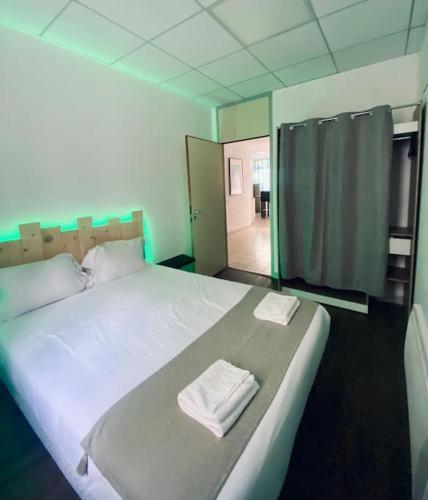 une chambre avec un grand lit avec deux serviettes dessus dans l'établissement *Bleu Saphir* centre de Vichy, à Vichy
