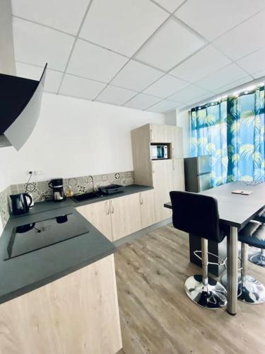 une pièce avec une cuisine avec une table et des chaises dans l'établissement *Bleu Saphir* centre de Vichy, à Vichy