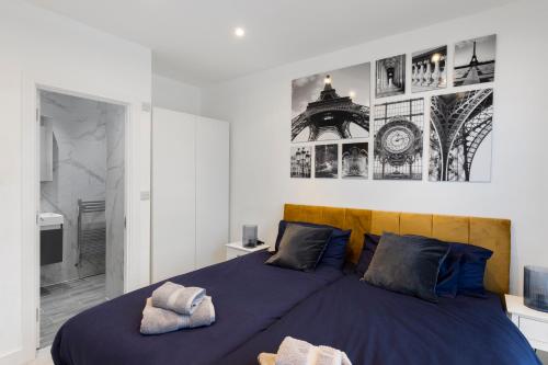 a bedroom with a large blue bed with two pillows at Star London Station Road 3-Bed Oasis with Garden in The Hyde