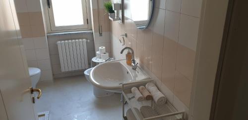 a white bathroom with a sink and a toilet at Regina Elena al mare in Pescara