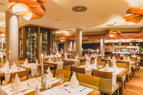 a restaurant with white tables and chairs and a bar at Hotel Balnea Superior - Terme Krka in Dolenjske Toplice