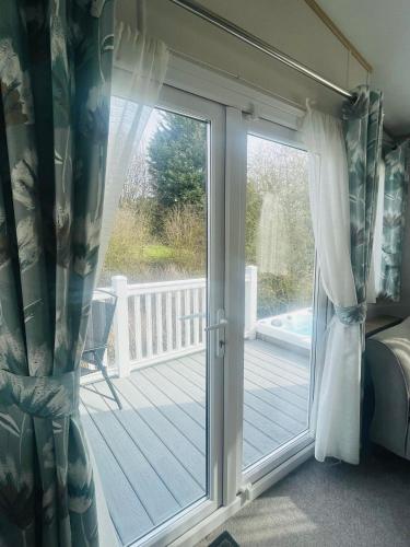 a sliding glass door leading to a deck at Yorkshire Lodge with Hot Tub in York
