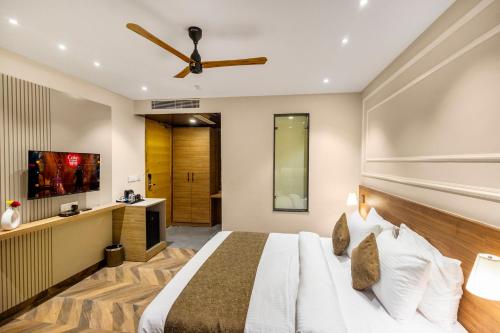 a hotel room with a bed and a flat screen tv at Pride Hotel And Resort Rishikesh in Rishīkesh