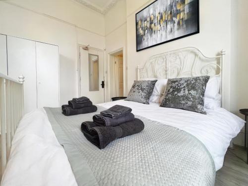 a bedroom with a white bed with towels on it at Erin Court Mansions - Suite 13 in Croydon