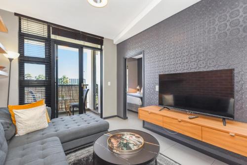 a living room with a large flat screen tv at Easy Stay - The Vantage Rosebank in Johannesburg