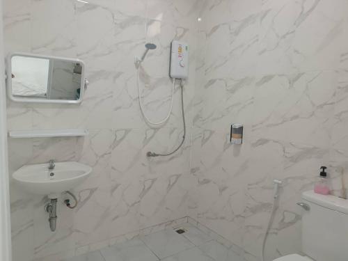 La salle de bains blanche est pourvue d'un lavabo et d'un miroir. dans l'établissement Ma Lay Resort, à Ban Pheng Krong