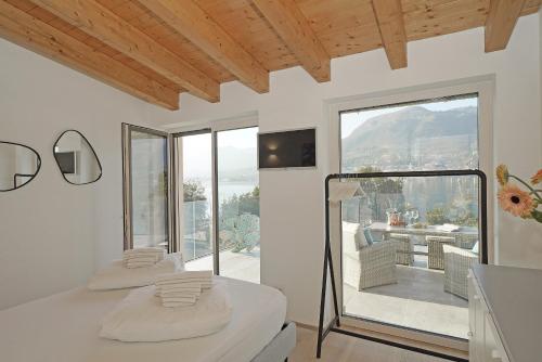 two beds in a room with a large window at Villa Bianca directly on the lake modern amazing in San Felice del Benaco
