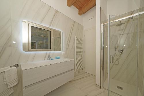 y baño blanco con lavabo y ducha. en Villa Bianca directly on the lake modern amazing, en San Felice del Benaco