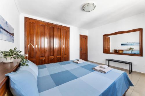 a bedroom with a blue bed and a mirror at Home2Book Charming Seashell Apartment Beachview in Playa Honda