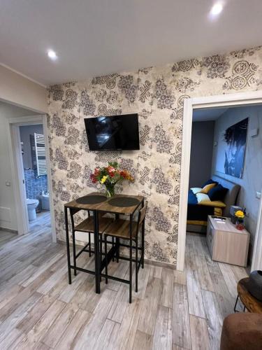 a living room with a table with flowers on a wall at Casa Anita in Mentana