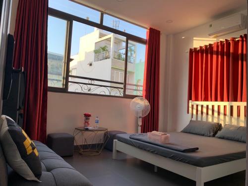 Elegant Hostel Sai Gon - District 3 في مدينة هوشي منه: غرفة معيشة مع سرير ونافذة كبيرة
