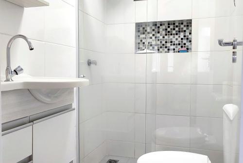 une salle de bain blanche avec douche et toilettes dans l'établissement Linda Casa Bairro tranquilo prox Cataratas, à Foz do Iguaçu