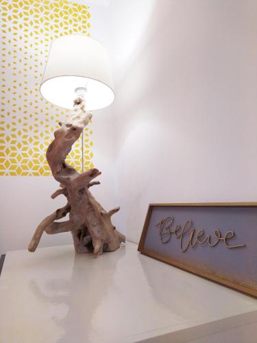 a table with a lamp and a sign that says believe at Villa dei Fiori in Luino