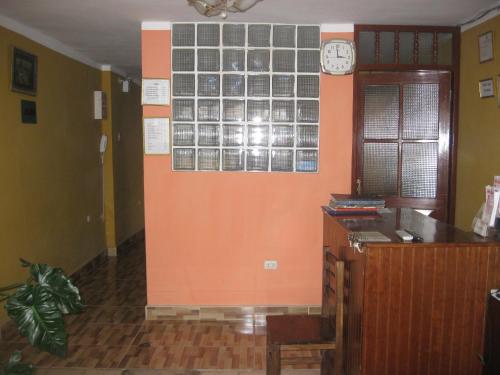 an office with a wall with a clock on it at Posada Gino in Pisco