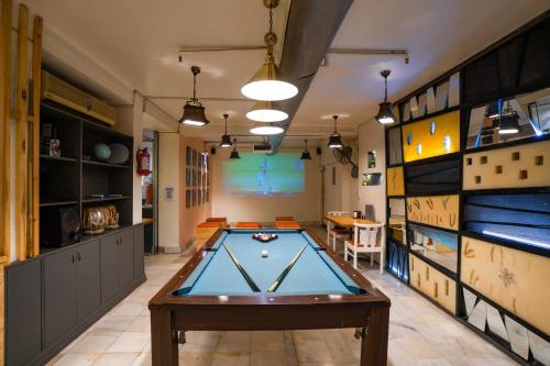 a pool table in a room with a screen at Zostel Delhi in New Delhi
