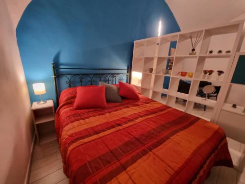 a bedroom with a red bed with a blue wall at majorana home in Naples