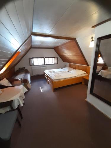 um quarto no sótão com 2 camas e uma janela em Pension Meandr em Cesky Krumlov