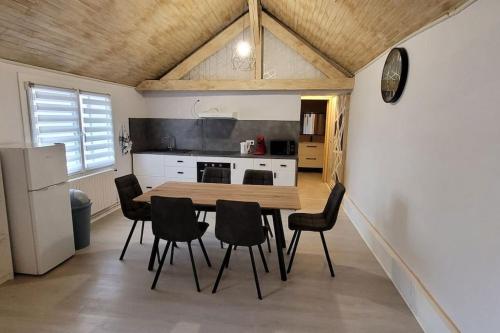 a kitchen with a table and chairs in a room at la maison de l'abeille de Percey in Percey-le-Pautel