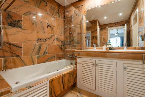a bathroom with a tub and two sinks and a bath tub at White Pearl Beach Elviria in Marbella