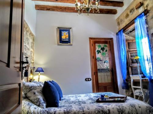 a bedroom with a bed with blue pillows at Habitación en casa con encanto, Úbeda in Úbeda
