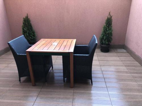 uma mesa de madeira com duas cadeiras e duas plantas em Hotel Rivoli em Bucareste